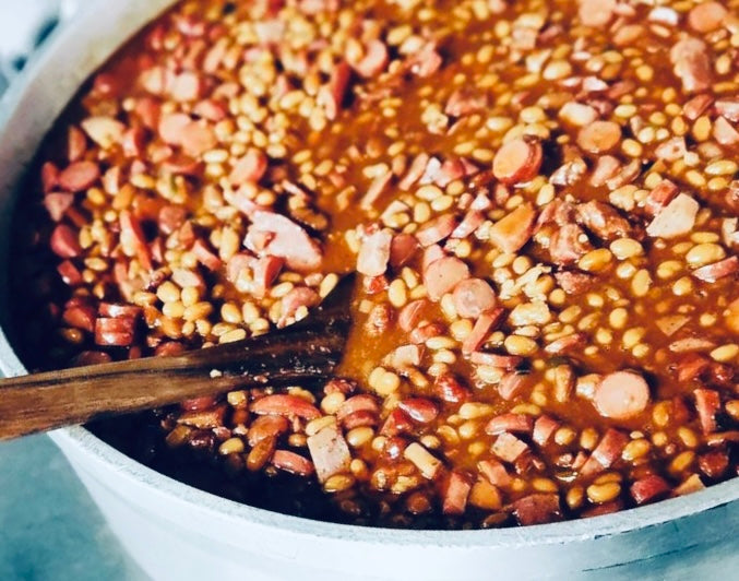 Pinto beans with bacon in a pot on a stove
